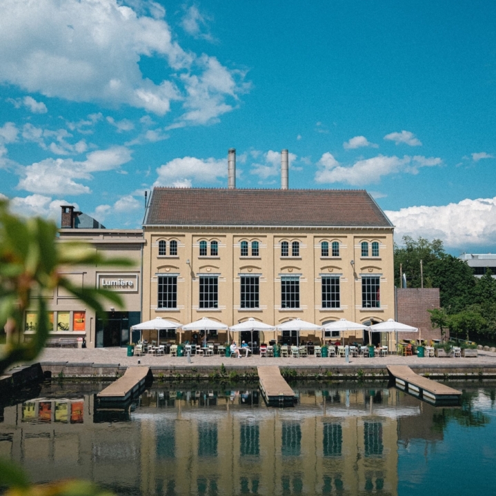 Vooraanzicht Lumière: het gebouw en het terras aan het water
